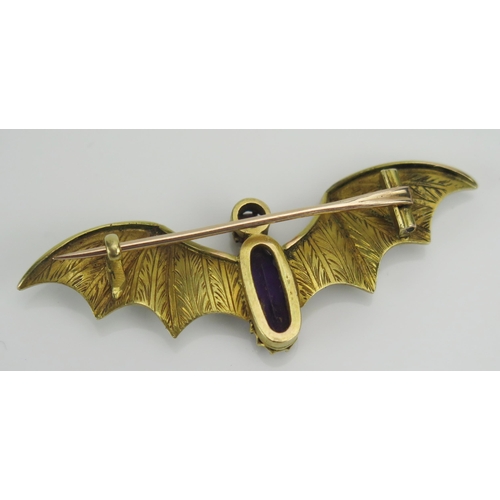 184 - A Suffragette Bat Brooch set with an amethyst and with green and white enamel wings and a further ru... 