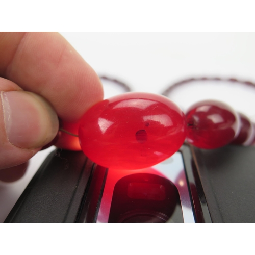 37 - Faux Cherry Amber Bead Necklace, largest bead c. 29.8x21.35mm, 77cm, 50.43g