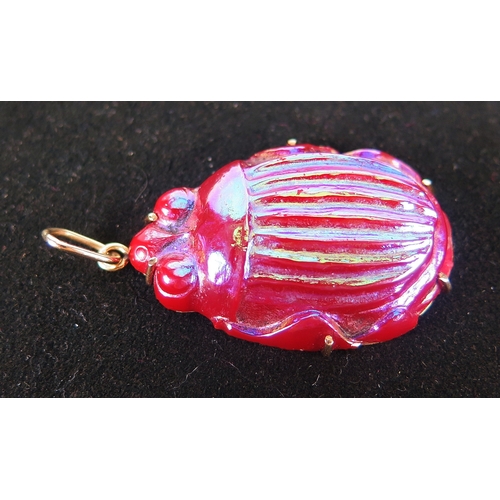 43 - A scarab beetle pendant in a precious yellow metal setting, in moulded iridescent glass, 48mm drop, ... 