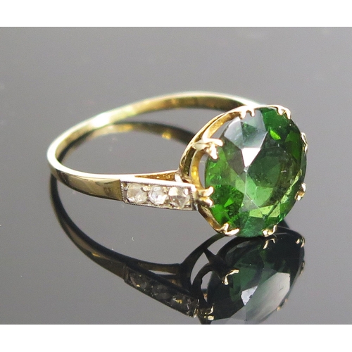 11 - A chrome diopside? ring in an 18ct gold and platinum setting with rose cut diamonds set to the shoul... 