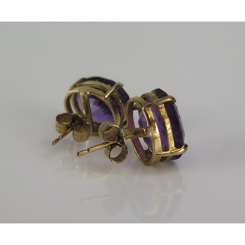 22 - A pair of amethyst studs in a 9ct yellow gold setting, c. 12x10mm stones, hallmarked, 3.76g