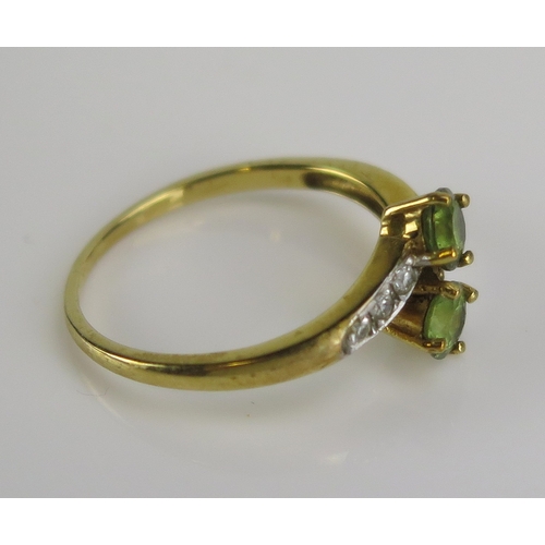 27 - A Shipton & Co peridot and diamond crossover ring in a 9ct yellow gold setting, size T, 2.73g. Sold ... 