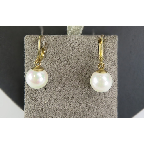 31 - A pair of cultured pearl pendant earrings in 14k yellow gold mounts (c. 30mm drop, 4.41g) and a pair... 