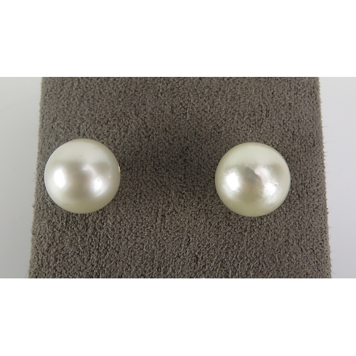 31 - A pair of cultured pearl pendant earrings in 14k yellow gold mounts (c. 30mm drop, 4.41g) and a pair... 