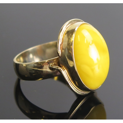 7 - An amber ring in a 9ct yellow gold setting, c. 21x16.5mm head, size P.75, hallmarked, 6.68g. Boxed