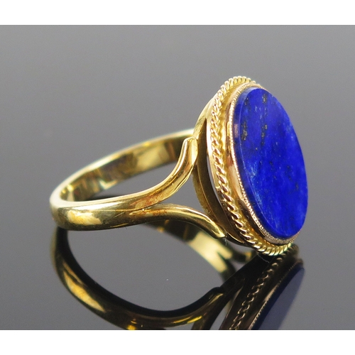 9 - A lapis lazuli ring in an 18ct gold setting, 20x17mm head, size V.5, stamped 18CT, 7.53g. Boxed