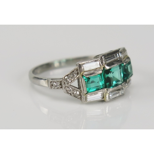 353 - A Deco style emerald and baguette cut diamond in a precious white metal setting, size O, Kee tests a... 
