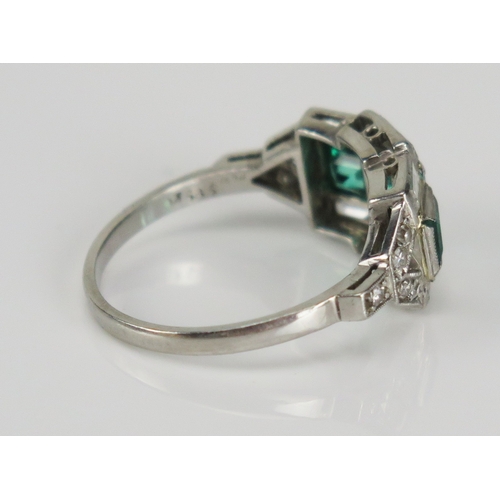 353 - A Deco style emerald and baguette cut diamond in a precious white metal setting, size O, Kee tests a... 