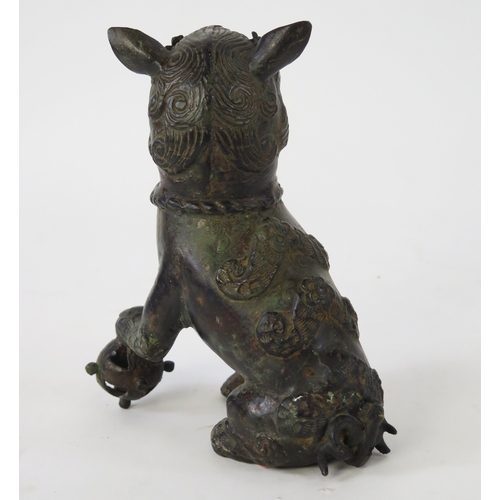 1101 - A Chinese bronze censer modeled as a Buddhistic lion, with one paw resting on a pierced globe, 20cm ... 