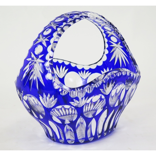 1108 - A clear glass and blue overlay glass basket, of oval form with arched handle, 27cm wide, 24cm high.