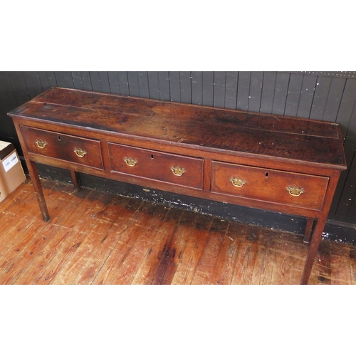 1761 - A late 18th century oak dresser base, the rectangular top with a moulded edge, above three short fri... 