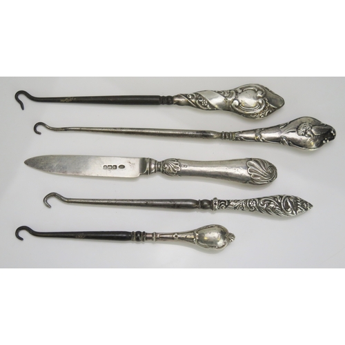 552 - Four silver handled button hooks together with a silver fruit knife