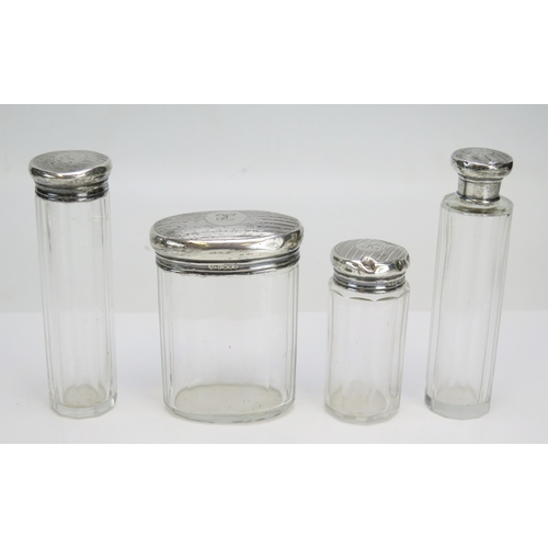573 - Four silver mounted glass dressing table jars, various makers and dates, total weighable silver 70.9... 