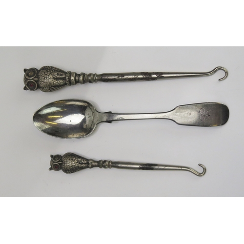 600 - A silver teaspoon and two silver owl finial button hooks, 20.24g weighable silver