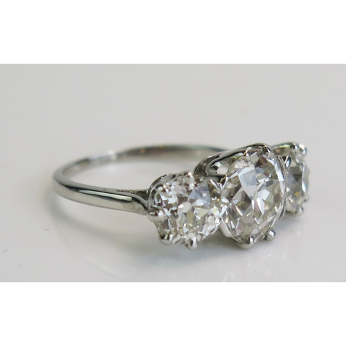 30 - A natural diamond three stone ring in a precious white metal setting, c. 8.7mm principal brilliant r... 