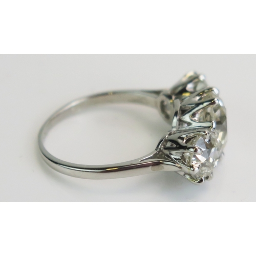 30 - A natural diamond three stone ring in a precious white metal setting, c. 8.7mm principal brilliant r... 