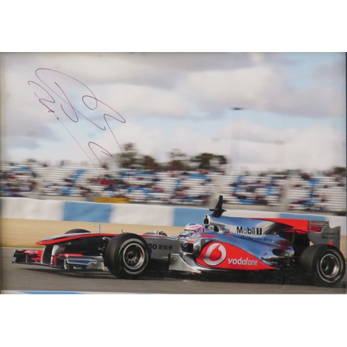 9 - Jenson Button two signed Formula 1 photographs, standing in racing kit and the other in car, one wit... 