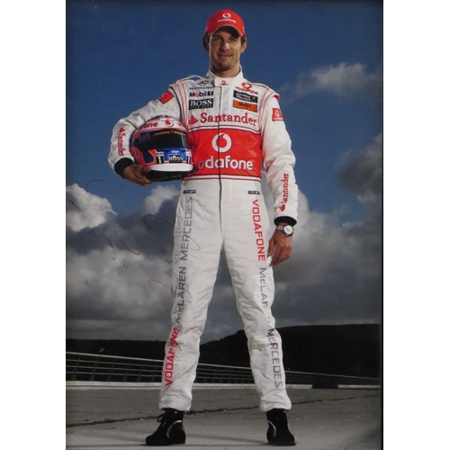 9 - Jenson Button two signed Formula 1 photographs, standing in racing kit and the other in car, one wit... 