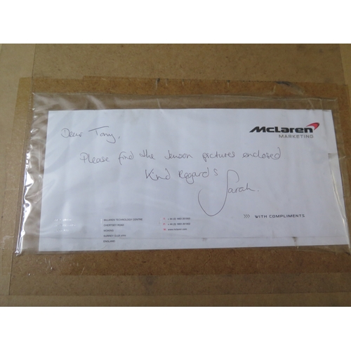 9 - Jenson Button two signed Formula 1 photographs, standing in racing kit and the other in car, one wit... 