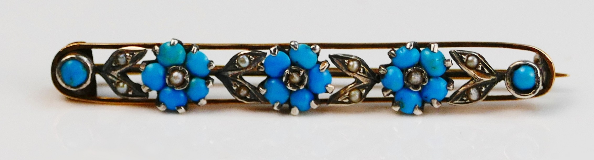An antique turquoise and seed pearl FORGET ME NOT brooch in a 9ctgold ...