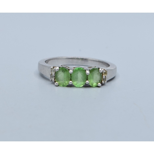 2556 - 925 silver ladies 3 stone Peridot dress ring with clear stone decoration to the sides size N