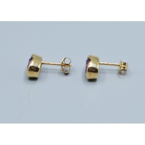 2563 - Pair 9ct gold Amethyst stud earrings in an enclosed setting Amethyst measures 9x6mm