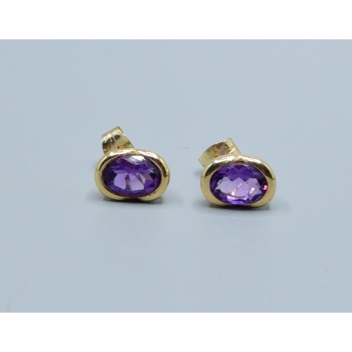 2563 - Pair 9ct gold Amethyst stud earrings in an enclosed setting Amethyst measures 9x6mm
