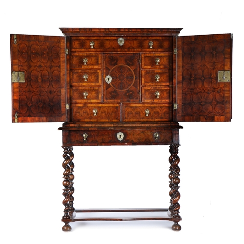 247 - A fine William & Mary oyster veneered cabinet and stand, the swept pediment above two oyster veneere... 