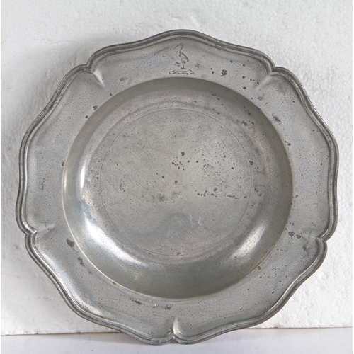 105 - A George III pewter wavy-edge dish, circa 1760

 The rim of five lobes, engraved with a stork crest ... 