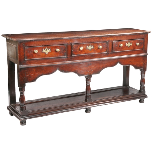 283 - A George II oak open dresser base, Montgomeryshire, circa 1740

 Having a boarded top, and three coc... 