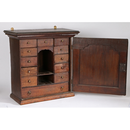 311 - A mid-18th century oak mural spice cabinet

 The stepped pediment above a fielded panelled door, ope... 