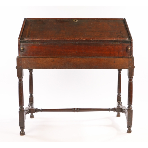 318 - A William and Mary / Queen Anne oak desk-on-stand, circa 16901710

 The fall front slope opening to... 