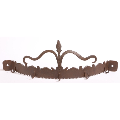 323 - An 18th century iron hanging utensil rack, English

 Of bowed form, having a highly stylized flower ... 