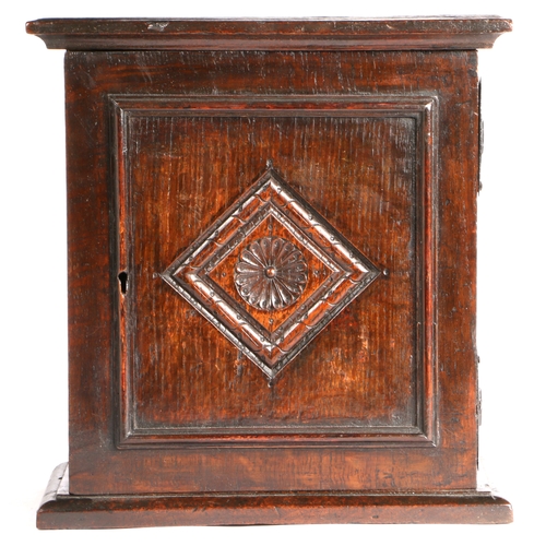 733 - A Charles II oak spice' cupboard, North Country, circa 1670

 The panelled door centred with a carv... 