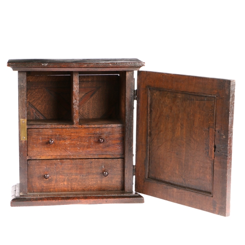 733 - A Charles II oak spice' cupboard, North Country, circa 1670

 The panelled door centred with a carv... 