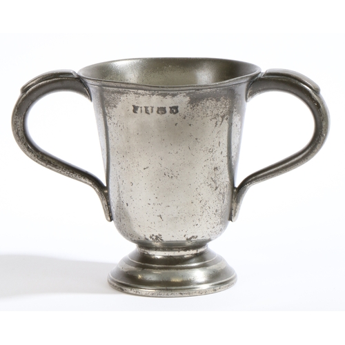 130 - A George III pewter twin-handled footed cup, circa 1800

 Having a tulip-shaped pint capacity drum, ... 