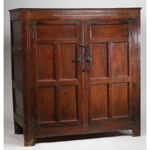 308 - A late 17th Century oak livery cupboard

 Having a pair of five-panelled cupboard doors, on extended... 