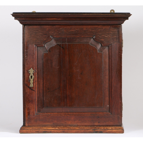 311 - A mid-18th century oak mural spice cabinet

 The stepped pediment above a fielded panelled door, ope... 