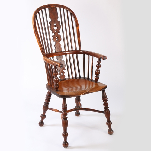 316 - An early 19th century yew and elm Windsor armchair

 The hooped back with spindles either side of a ... 