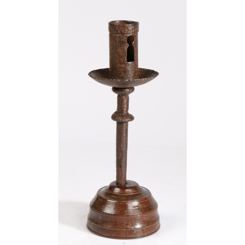 320 - A 16th century iron socket candlestick, on an early 19th century turned lignum vitae base 

 The par... 