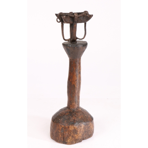 322 - A wrought-iron and timber oil-type lamp

 Having a cruise-lamp type reservoir, on a primitive pillar... 