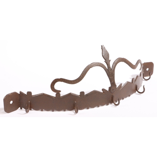 323 - An 18th century iron hanging utensil rack, English

 Of bowed form, having a highly stylized flower ... 