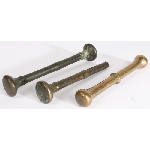 402 - Three 17th/18th century bronze alloy pestles, English

 Each centred by a fillet, longest 22cm, (3)