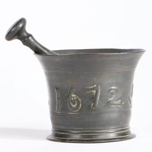 405 - A Charles II bronze alloy mortar and pestle, Suffolk, dated 1672

 The flared body cast with the dat... 