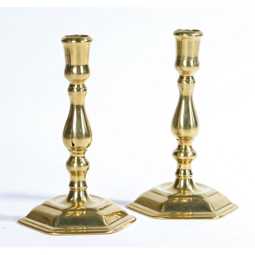 412 - A pair of George I seamed brass candlesticks, circa 1720

 Each with a thistle-shaped sconce, balust... 