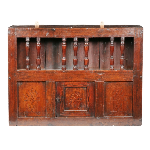 652 - A Charles II oak and inlaid mural spindle livery cupboard, circa 1660

 Having a row of seven turned... 