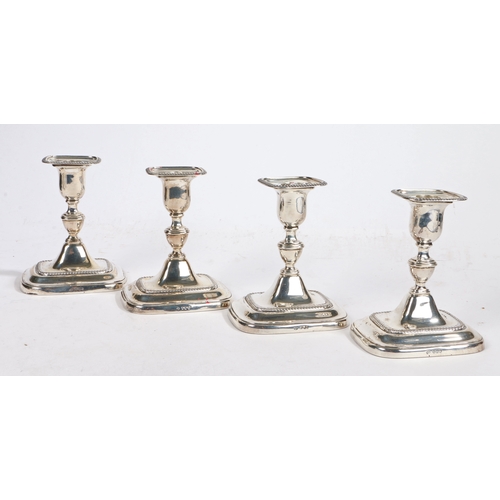 15 - A set of four George V silver candlesticks, Sheffield 1918, maker William Hutton & Sons Ltd. the det... 