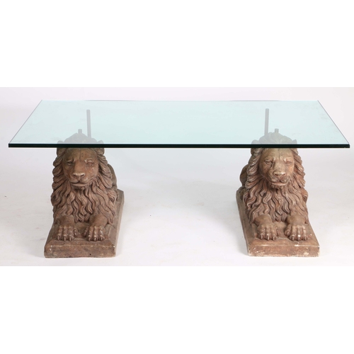 405 - A 20th Century coffee table, with a rectangular glass top above two reconstituted reclining lions, 1... 