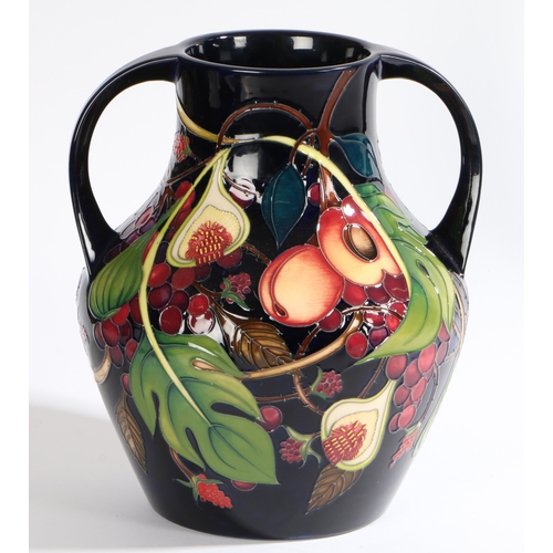 98 - A Moorcroft twin handled pottery vase decorated in the Queens Choice pattern, circa 2000,  painted m... 