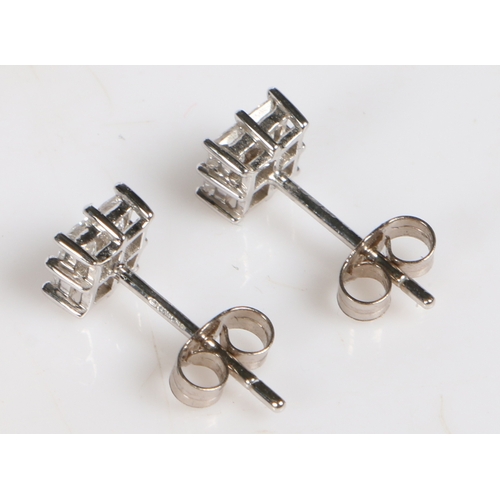 12 - A pair of 18 carat white gold and diamond set ear studs, of square form each set with four square cu... 